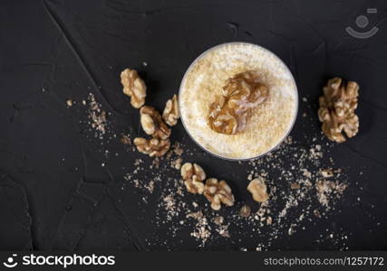 white chocolate mousse covered with nuts on a black background