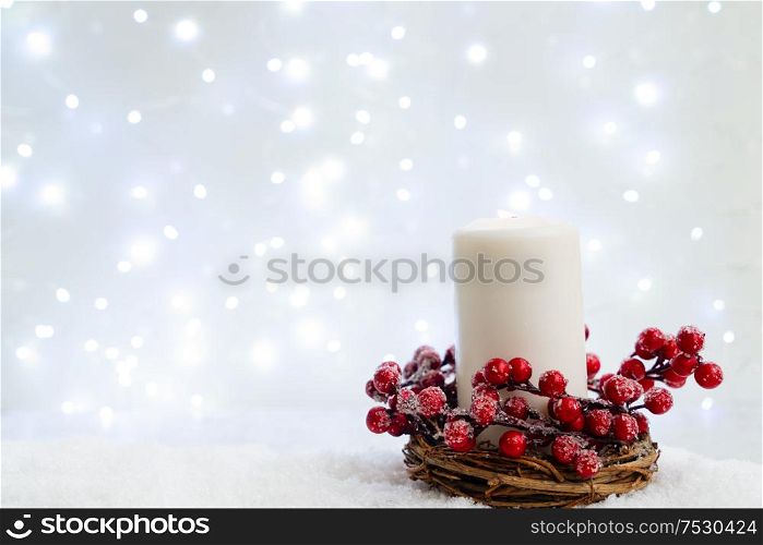 White christmas - burning candle in snow, blue night with lights in background. Happy Christas and holidays concept.. White christmas with snow