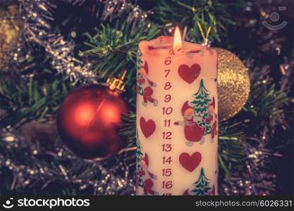 White Christmas candle with a december calendar