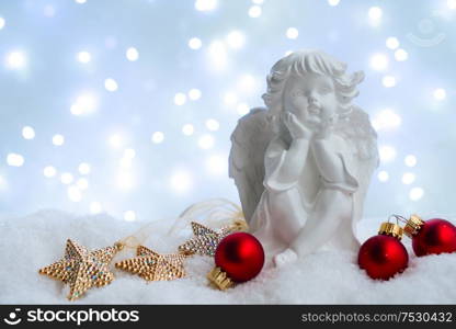 White christmas - cute angel in snow , blue night with lights in background. Happy Christas and holidays concept.. White christmas with snow