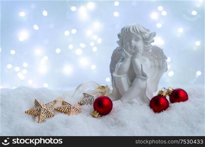 White christmas - cute angel in snow , blue night with lights in background. Happy Christas and holidays concept.. White christmas with snow