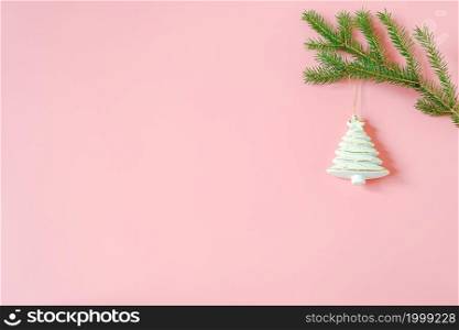 White christmas decoration tree toy on fir branch on pink background with copy space. Concept Merry christmas or Happy new year. Minimal style Top view Flat lay Template for design, card, invitation.. White christmas decoration tree toy on fir branch on pink background with copy space. Concept Merry christmas or Happy new year. Minimal style Top view Flat lay Template for design, card, invitation