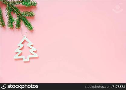 White christmas decoration tree toy on fir branch on pink background with copy space. Concept Merry christmas or Happy new year. Minimal style Top view Flat lay Template for design, card, invitation.. White christmas decoration tree toy on fir branch on pink background with copy space. Concept Merry christmas or Happy new year. Minimal style Top view Flat lay Template for design, card, invitation