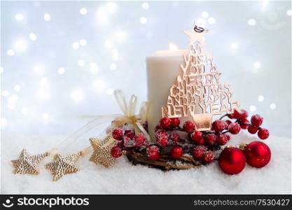 White christmas - glowing candle and decorations in snow, blue night with lights in background. Happy Christas and holidays concept.. White christmas with snow