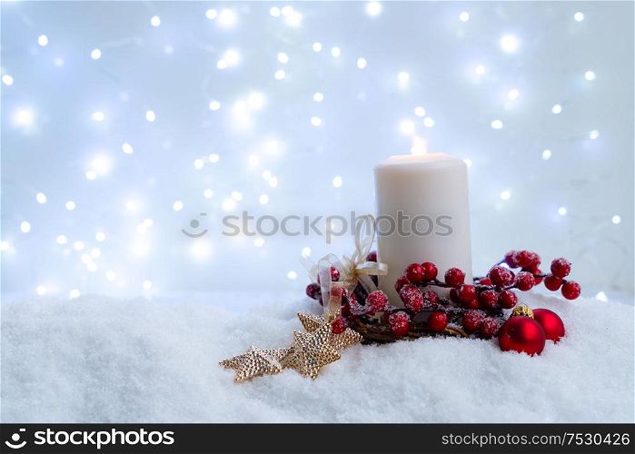 White christmas - glowing candle in snow, blue night with lights in background. Happy Christas and holidays concept.. White christmas with snow