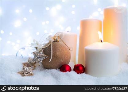 White christmas - glowing candle in snow, blue night with lights in background. Happy Christas and holidays concept.. White christmas with snow