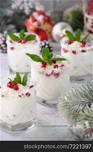 White Christmas mojito made from liqueur, tequila, coconut milk with pomegranate seeds, coconut flakes and refreshing mint.