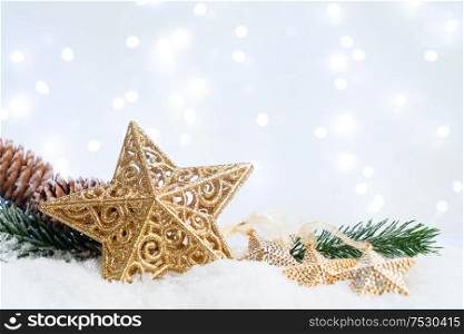 White christmas with snow - evergreen twigs and christmas star with lights in background. White christmas with snow