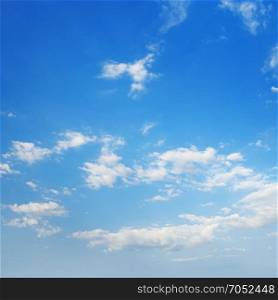 White cirrus clouds against a blue sky.