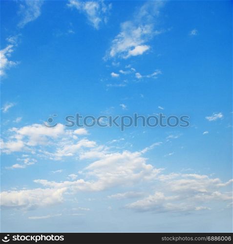 White cirrus clouds against bright blue sky.