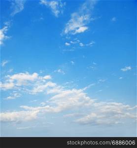 White cirrus clouds against bright blue sky.