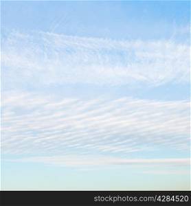 white cirrus clouds in blue afternoon sky in October