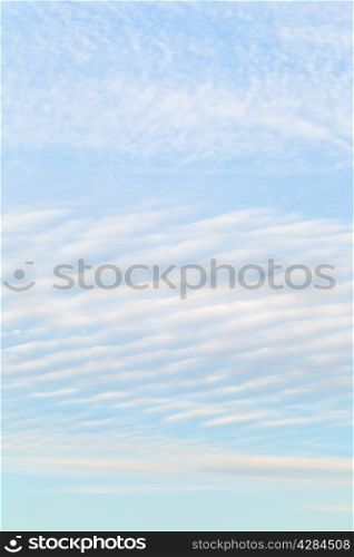 white cirrus clouds in blue evening sky in October