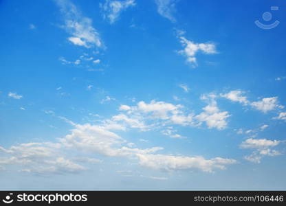 White cirrus clouds in bright blue sky.