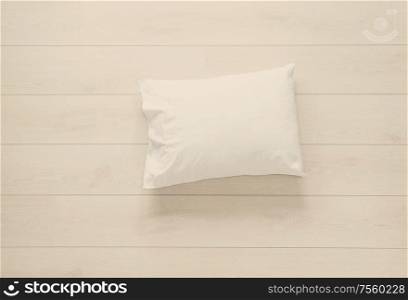 white clean pillow on the wooden floor background. white pillow on the floor