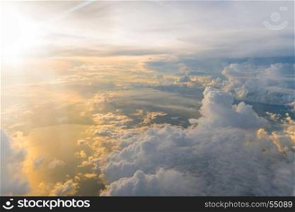 White clouds and blue sky at sunrise, view from above air plane window.
