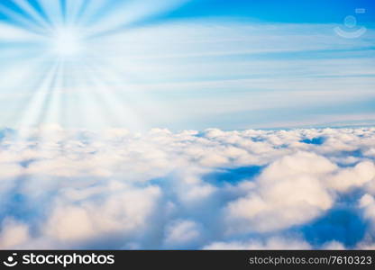 White clouds on blue sky with sun rays as cloudscape nature background