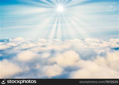 White clouds on blue sky with sun rays as cloudscape nature background