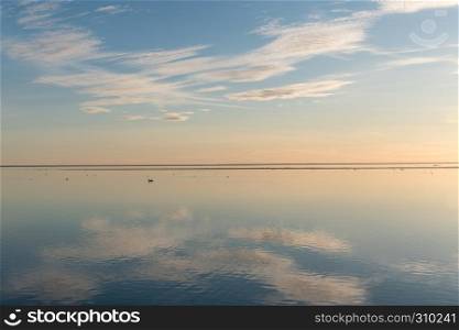 White clouds reflecting in absolutely calm water by the coast of the swedish island Oland in the Baltic Sea