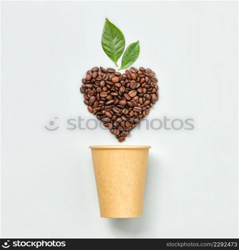 White coffee cup and coffee beans in shape of heart on white background, top view. White coffee cup and coffee beans in shape of heart on white background, flat lay