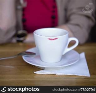 White coffee cup and saucer with trace of red lipstick