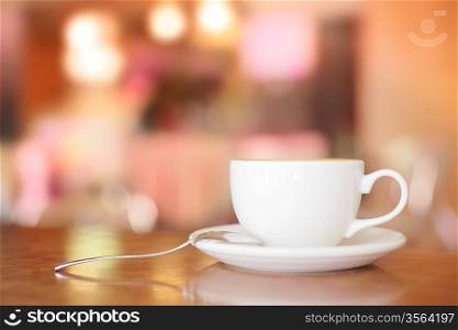 White Coffee Cup on brown wooden table with bokeh