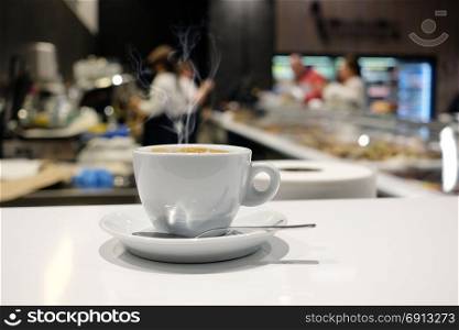 White coffee cup on the table in cafe interior