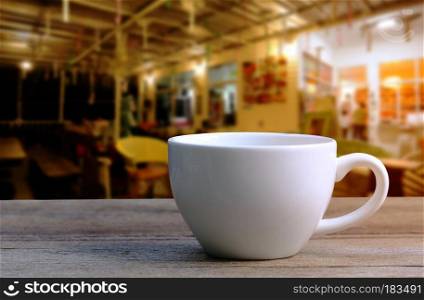 White Coffee cup on wooden table in coffee shop blur background,vintage style effect picture.