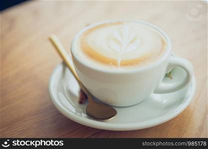 white coffee mug. Coffee is a latte. table on the wooden table in vintage style, taken from the top view, see the froth of milk foam.