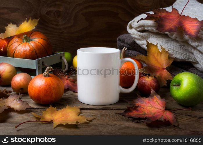 White coffee mug mockup with fall maple leaves, apples and pumpkins. Empty mug mock up for design promotion.