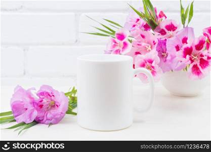 White coffee mug mockup with pink godetia clarkia flowers. Empty mug mock up for design promotion.