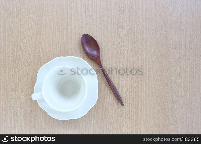 White coffice cup and wooden spoon in top view on wood background for design concept food.