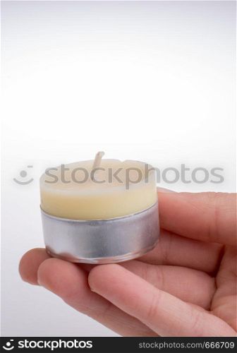 White color small Candle in hand on a white background