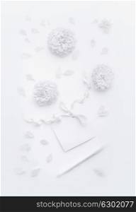 White composition with flowers, blank paper card with ribbon and pencil , flat lay, top view. Mock up for greeting of Mothers day, birthday, Valentine?s Day, wedding or happy event