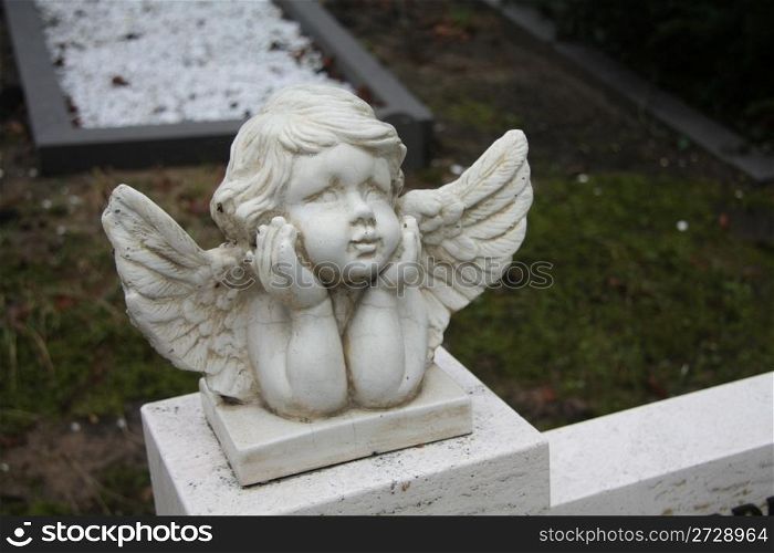 white concrete Guardian Angel grave ornament on a graveyard