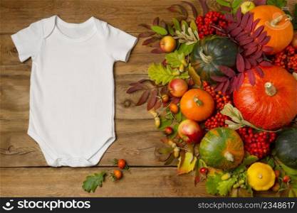 White cotton baby short sleeve onesie mockup with apples, pumpkins and fall leaves. Design gender neutral bodysuit template, newborn romper print presentation mock up