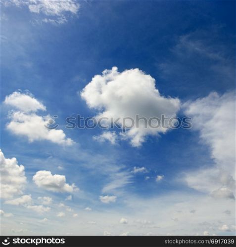 White cumulus clouds on the background of an epic dark blue sky.