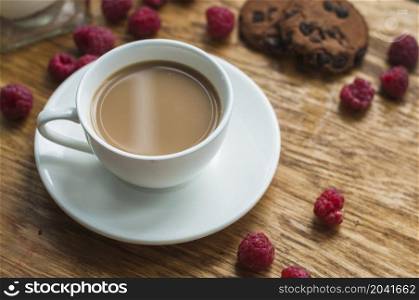 white cup coffee with chocolate cookies raspberries wooden background