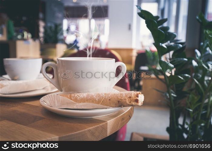 White cup of coffee at the cafe interior