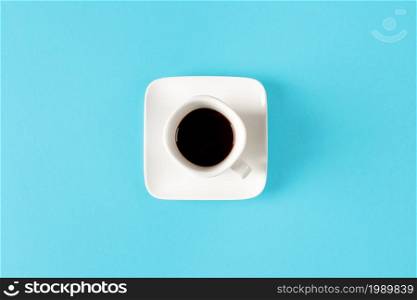 White cup of coffee isolated on a blue background. minimal style.