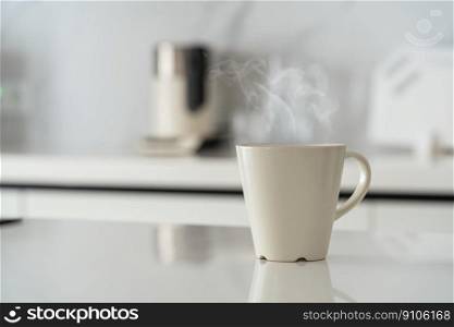 White cup of coffee on white kitchen table over blured kitchen interior background. White cup on white table