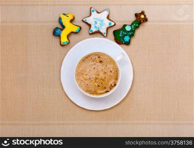 White cup of hot beverage drink coffee cappuccino latte with christmas handmade gingerbread cakes with icing sweet dessert. Holiday concept.