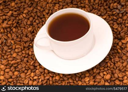 White cup on the background of coffee beans