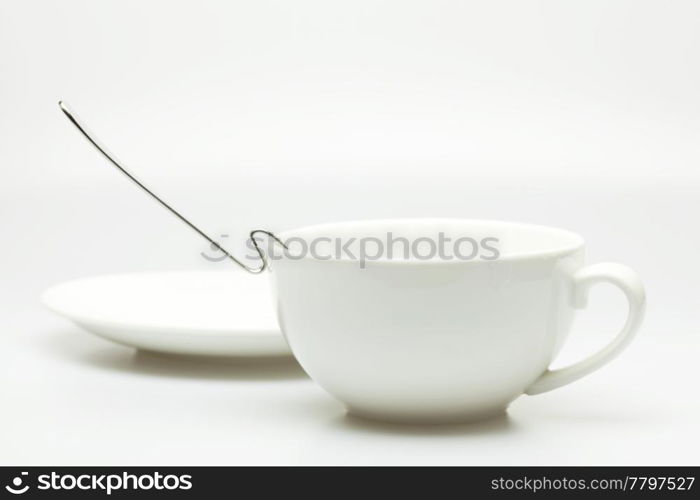 white cup, saucer and spoon isolated on white