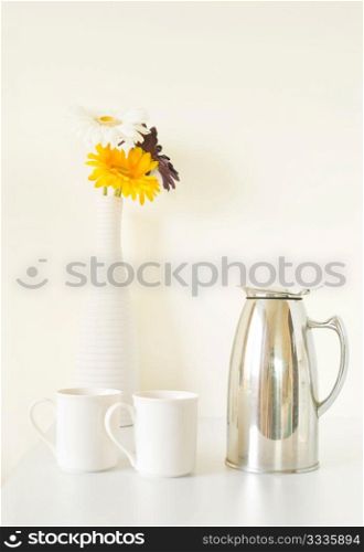White cup set and vase on white table