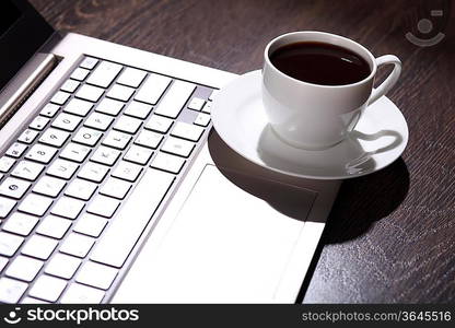 White cup with black coffee at business workplace