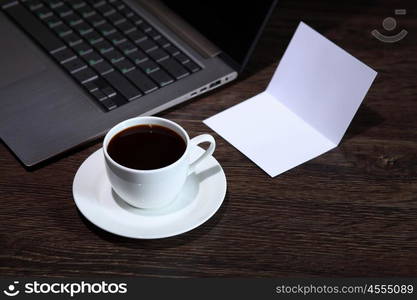 White cup with black coffee at business workplace