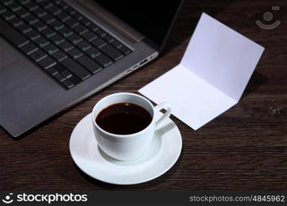 White cup with black coffee at business workplace