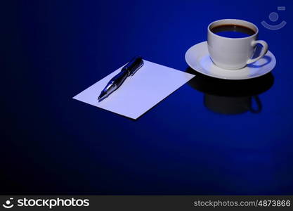 White cup with black coffee at business workplace