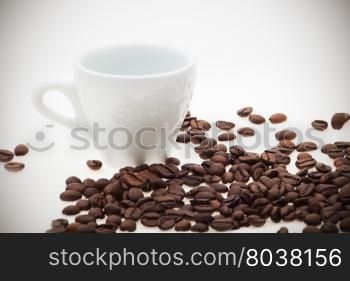 white cup with coffee beans. background